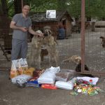 Frank steht vor dem Tor des Asyls Riska in Belgrad/Serbien. Er hat Hundefutter mitgebracht. Hinter dem Tor sieht man Hunde des Tierheims.